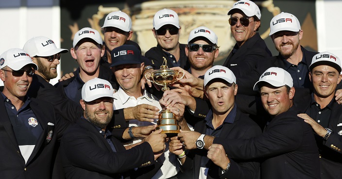 United States captain Davis Love III is surrounded by his players as they pose for a picture during the closing ceremony of the Ryder Cup golf tournament Sunday, Oct. 2, 2016, at Hazeltine National Golf Club in Chaska, Minn. (AP Photo/David J. Phillip)