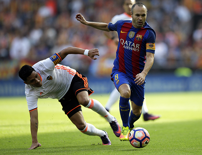 FC Barcelona's Andres Iniesta, right, dribbles past Valencia's Enzo Perez during the Spanish La Liga soccer match between Valencia and FC Barcelona at the Mestalla stadium in Valencia, Spain, Saturday, Oct. 22, 2016. (AP Photo/Manu Fernandez)