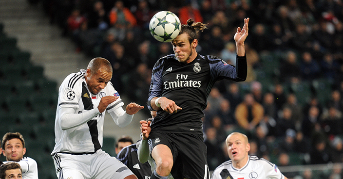 Real Madrid's Gareth Bale, right, battles for the ball with Legia's Vadis Odjidja during the Champions League Group F soccer match between Legia Warsaw and Real Madrid, at Stadion Wojska Polskiego, in Warsaw, Poland, Wednesday, Nov. 2, 2016. The match is played at the empty stadium because of earlier fan trouble during a Champions League match against Borussia Dortmund. (AP Photo/Alik Keplicz)