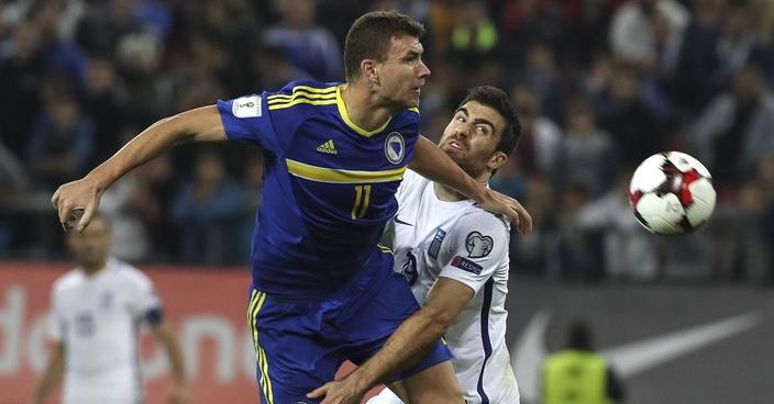 Bosnia's Edin Dzeko, left, struggles for the ball against Greece's Sokratis Papastathopoulos during their World Cup Group H qualifying soccer match at Georgios Karaiskakis Stadium, in Piraeus port, near Athens, on Sunday, Nov. 13, 2016. (AP Photo/Yorgos Karahalis)