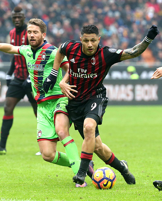 Crotone's Marcus Rohden, left, challenges for the ball with AC Milan forward Gianluca Lapadula during their Serie A soccer match at the San Siro stadium in Milan, Italy, Sunday, Dec. 4, 2016. (Matteo Bazzi/ANSA via AP)