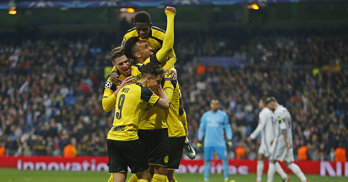 Dortmund players celebrate after Marco Reus scored his side's 2nd goal during the Champions League, Group F, soccer match between Real Madrid and Borrusia Dortmund at the Santiago Bernabeu stadium in Madrid, Spain, Wednesday, Dec. 7, 2016. (AP Photo/Francisco Seco)