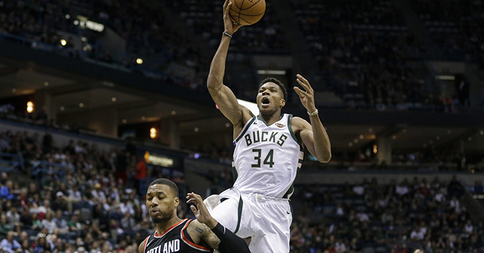 Milwaukee Bucks' Giannis Antetokounmpo (34) shoots over Portland Trail Blazers' Damian Lillard during the first half of an NBA basketball game Saturday, Oct. 21, 2017, in Milwaukee. (AP Photo/Tom Lynn)