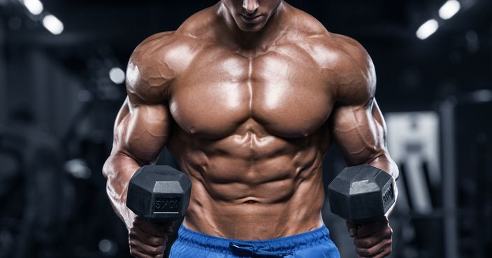 Muscular man working out in gym, strong male torso abs