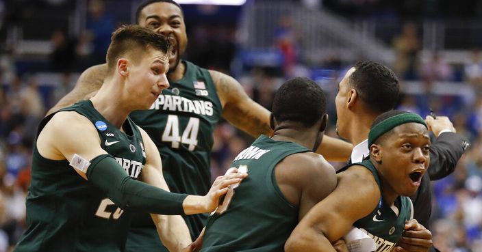 Michigan State guard Cassius Winston, right, celebrates with teammates Matt McQuaid (20), Nick Ward (44) and Gabe Brown (13) after defeating Duke in an NCAA men's East Regional final college basketball game in Washington, Sunday, March 31, 2019. (AP Photo/Patrick Semansky)