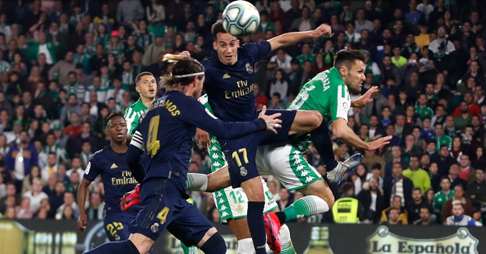 Real Madrid's Lucas Vazquez jumps for the ball against Betis' Alfonso Pedraza during La Liga soccer match between Betis and Real Madrid at the Benito Villamarin stadium in Seville, Spain, Sunday, March. 8, 2020. (AP Photo/Miguel Morenatti)